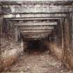 Cults Hill Limestone Quarry/Cults Lime Works.  View from N of interior of 20th century limestone mine, showing steel roof sopports and brick-wall lining to the level.  Also visible is the double-track tramway remains with some of the metal and wooden sleepers still in situ.