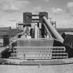 View from S looking into the receiving hopper of the primary crusher, with the two shaft kilns (and conveyor) in background