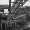 View from N at middle level of shaft kilns, showing the conveyor taking crushed limestone to the former kilns for storage.  The base of the crusher is visible, as is a surviving portion of one of the old conveyors used to charge the shaft kilns when they were in operation