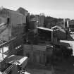 Elevated view from NE (at middle level of shaft kilns) of W end of lime works, showing part of dryer and hammer mill (left), and ball mills in background (centre)