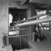 Detailed view of base of one of the two shaft kilns, showing bottom of hopper and belt conveyor