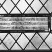 Detail of stained glass memorial plaque inscribed ' These windows were restored on 1988 in memory of The Rev J K Russell, MA BD Minister of the parish 1912-1949'