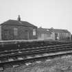 View from E of outbuilding and shed at end of N-bound platform at W side of station