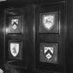 Ground floor, library, left side, fireplace panelled surround, heraldic shields, detail