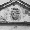 Detail of armorial panel on pediment at South end of West front.
