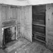 Interior. View of second floor East room/housekeepers room from North showing fireplace and fitted cupboards.