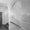 Interior. View of rusticated stairwell arches.