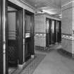 Interior. View of the two blocks of three cubicles, a further pair of cubicles being located beyond (out of picture).  All the original water closets and cisterns appear to have been removed, but most cubicles retain the green tilework.