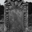 Inveraray, Kilmalieu Burial Ground,
View of gravestone of Gilbert Campbell, 1765 with a curved broken pediment, with a winged soul crowned with laurels, signifying victory over death. With a chain of bluebells from the pediment supports.
