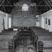 Interior. View from E showing boarded walls and pews from the vhurch on The Oa