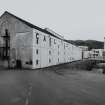 Islay, Caol Ila Distillery.
View of distillery from SSE, with bonded warehouse occupying the S end of the distillery complex in the foreground