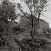 Jura, Craighouse, Grain Mill
View from SW of SW gable (showing iron remains of water-wheel hub) and SE side of mill building, with remains of the lade also partly visible