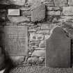 Keills Old Parish Church, interior, gravestones.
General view of stones on West wall.

