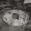Detail of circular stone resembling a buried monolithic millstone, said to have been used in the process of forming the rims of cart wheels, photographed 27 October 1993