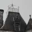 Roof, chimney, top of tower, window surmounted by coat of arms and finials, detail