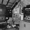 Interior. View within winding-engine house showing electrical switchgear (left), and lamp-battery chargers and self-rescuers (right).