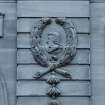 Detail of carved head within wreath on north facade