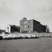 General view from SE of former cotton mill (right) and rear of stationery warehouse (left), also showing the stump of the boilerhouse chimney