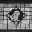 Interior, view of ground floor library figurative stained glass window depicting a bust of Homer