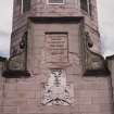 Detail of memorial plaque with coat of arms below.