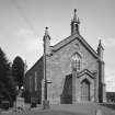 General view from W showing entrance porch and bellcote.