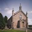 General view from W showing entrance porch and bellcote.