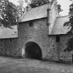 View of central entrance of coach-house with doocot above from E.