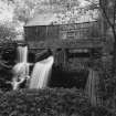 View of lade as it approaches the mill.  The lade bypass is in full use, taking water away from the water-wheel.  At the time of survey, the water wheel was not in use because the chain drive connecting it with the mill machinery was requiring repair.