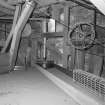 Interior.
Detailed view at attic level in the mill, showing belt-driven pulleys, the summit of bucket elevators, and the central vertical line shaft which runs up inside the mill from the gear cupboard below.