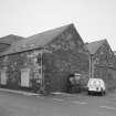 General view from NW, showing old granary (left), and three bays of fish processing works (right)