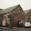 General view from NW, showing old granary (left), and three bays of fish processing works (right)