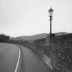 View from S showing typical lamp standard, parapet, and tarmac deck