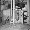Interior.
View of ground-floor level, showing winnowing machine (centre), with machinery of gear cupboard partially visible behind.