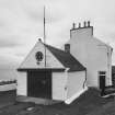 Detailed view from E of coastguard station, with houses behind