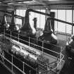 Interior view from N within still house block, showing 6 stills and spirit safes.