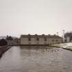 View across dam from SW of central buildings of distillery.