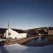 General view from SW of warehouses nos 5 and 7, dam and central buildings of distillery.