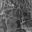RAF WW II vertical air photograph of the central area of Elgin.  Visible is the E end of the High Street with St Giles Church, Cooper Park and the gasworks.