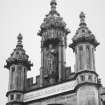 Detail of crocketed pinnacles and statue in niche of tower on N face.