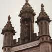 Detail of crocketed pinnacles and statue in niche of tower on N face.