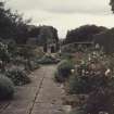 View of sundial and herbaceous borders in the walled garden.