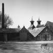 View from ESE of Still House, former Kilns and Mash House, and Boiler House chimney.
