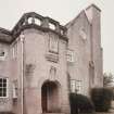 View of main N entrance from NNE with elaborately carved oriel window above