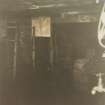 Interior.
Photographic copy of colour polaroid showing view of curing house with kiln door in background and dripping rack in foreground.