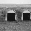 View from SW of a pair of torpedo store huts.