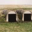 View from SW of a pair of torpedo store huts.