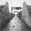 View from NW looking along rear corridor of bomb store sheds showing bomb loading gantries.