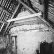 Building D, east apartment ('room'), showing cruck (behind secondary timbers) and  
stone-and-wattle partition