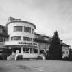 View of 3-storey circular flat roofed drum from E