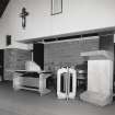 Interior. Detail of lecturn, font and communion table without cloth covering.